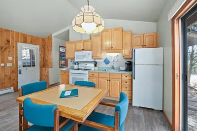a kitchen with a table and chairs and a refrigerator at McGregor Mountain Lodge in Estes Park