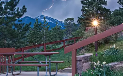 a table and bench in front of a storm at McGregor Mountain Lodge in Estes Park