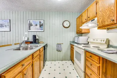 a kitchen with wooden cabinets and a sink and a stove at Convenient Winter Park, Colorado, Vacation Rental! in Winter Park
