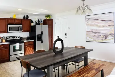 a kitchen with a wooden table with chairs around it at Change Your Altitude in Denver 3BR near Denver Airport w/GameRoom in Denver