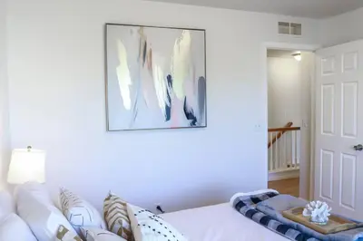 a bedroom with a white couch and a picture on the wall at Change Your Altitude in Denver 3BR near Denver Airport w/GameRoom in Denver