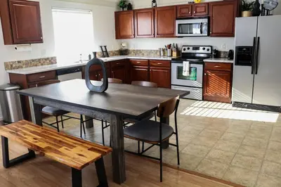 a kitchen with a table with chairs and a refrigerator at Change Your Altitude in Denver 3BR near Denver Airport w/GameRoom in Denver