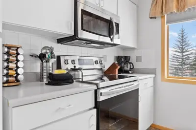 a white kitchen with a stove and a microwave at Cozy Frisco Condo Near Lake and Trails in Frisco