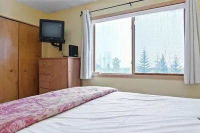 a bedroom with a bed and a tv and a window at Cozy Frisco Condo Near Lake and Trails in Frisco