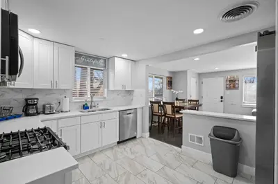 a kitchen with white cabinets and a dining room at Golfers Dream! Sweet NW location. in Arvada