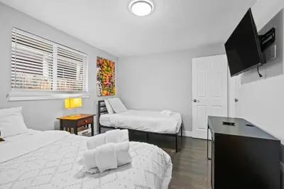 a bedroom with two beds and a desk with a tv at Golfers Dream! Sweet NW location. in Arvada