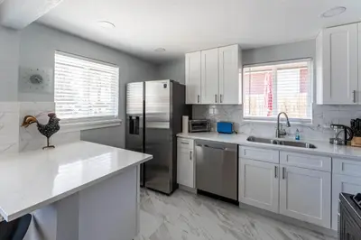 a kitchen with white cabinets and a stainless steel refrigerator at Hidden Gem of Arvada! in Arvada