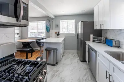 a kitchen with white cabinets and a stove top oven at Hidden Gem of Arvada! in Arvada