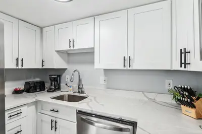 a white kitchen with a sink and white cabinets at All New! Convenient Location! Sleeps 6 in Denver