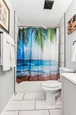 a bathroom with a palm tree shower curtain at All New! Convenient Location! Sleeps 6 in Denver
