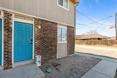 a brick house with a blue door on the side of it at All New! Convenient Location! Sleeps 6 in Denver