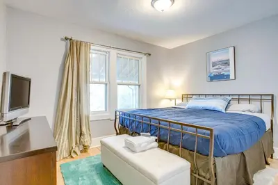 a bedroom with a blue bed and a tv at Less Than 1 Mi to Washington Park Denver Vacation Rental in Denver