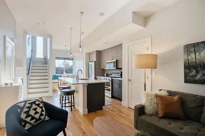 a living room with a couch and a kitchen at 2 BDR Home Roof Deck plus Walk to Broncos and Sloans Lake in Denver