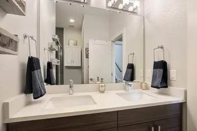 a bathroom with a sink and a large mirror at 2 BDR Home Roof Deck plus Walk to Broncos and Sloans Lake in Denver