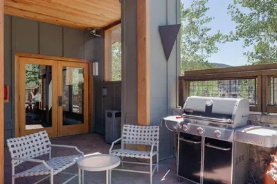 a patio with a grill and two chairs and a table at 2BR Ski In Ski Out Keystone Condo Walk to Slopes in Dillon