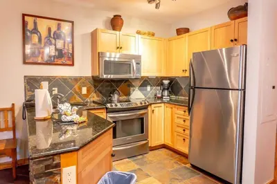 a kitchen with stainless steel appliances and wooden cabinets at 2BR Ski In Ski Out Keystone Condo Walk to Slopes in Dillon