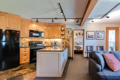 a kitchen with wooden cabinets and a black refrigerator at Iron Horse C5013 condo in Winter Park