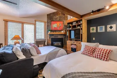 a bedroom with two beds and a couch and a tv at Iron Horse C5013 condo in Winter Park