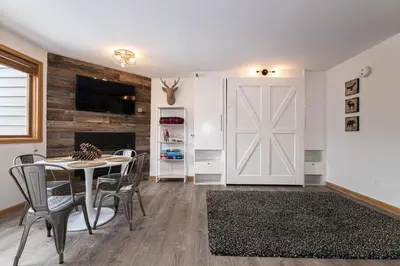 a dining room with a table and chairs and a barn door at Iron Horse C3013 condo in Winter Park
