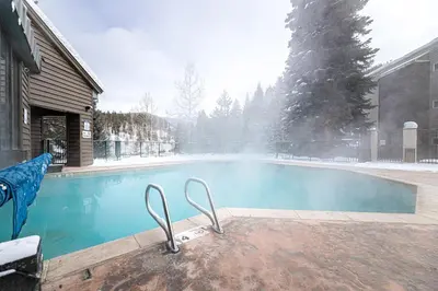 a swimming pool in a yard with snow on it at Iron Horse C3013 condo in Winter Park