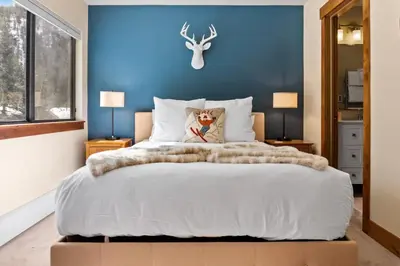 a bedroom with a large bed with a blue wall at 2BR Keystone Condo Near Slopes in Keystone