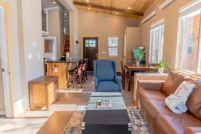 a living room with a couch and a kitchen at 2BR Riverside Chalet Near Trails in Breckenridge