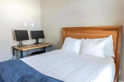 a bedroom with a bed and two desks with monitors at 2BR Riverside Chalet Near Trails in Breckenridge