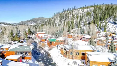 a town covered in snow with a mountain in the background at 2BR Riverside Chalet Near Trails in Breckenridge