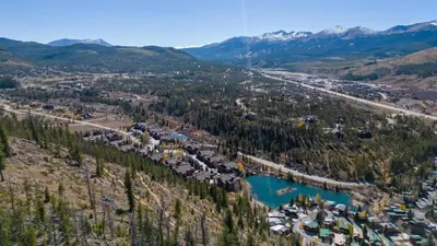 an aerial view of a resort with a lake and mountains at 2BR Riverside Cabin Near Trails with Hot Tub Access in Breckenridge