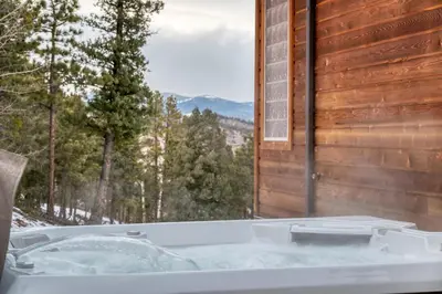a bath tub sitting next to a window at BEST VIEWS! Luxury Mountain Home - Saltwater HotTub, Firepit, BBQ- Close to SKI, Red Rocks in Evergreen