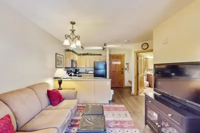a living room with a couch and a flat screen tv at Buffalo Lodge 1 Bedroom In River Run in Keystone
