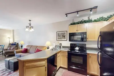 a kitchen with a counter top and a living room at Buffalo Lodge 1 Bedroom In River Run in Keystone