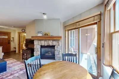 a living room with a table and a fireplace at Buffalo Lodge 1 Bedroom In River Run in Keystone