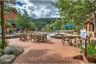 a patio with tables and chairs next to a pool at Buffalo Lodge 1 Bedroom Condo In River Run Village in Keystone