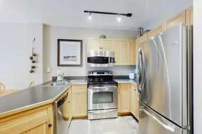 a kitchen with a stainless steel refrigerator and a sink at Buffalo Lodge 1 Bedroom Condo In River Run Village in Keystone