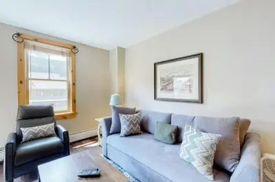 a living room with a blue couch and a chair at Buffalo Lodge 1 Bedroom Condo In River Run Village in Keystone