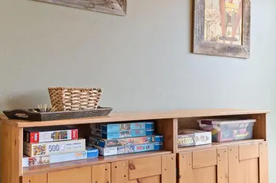 a wooden book shelf filled with books next to a wall at Cozy 2BR with Great Views Near Trails in Silverthorne