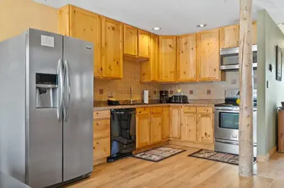 a kitchen with wooden cabinets and a stainless steel refrigerator at Cozy 2BR with Great Views Near Trails in Silverthorne