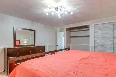 a bedroom with a red bed and a mirror at 8 Mi to Dtwn Denver Wheat Ridge Gem with Patio in Wheat Ridge