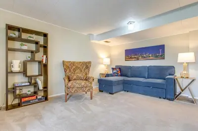 a living room with a blue couch and a chair at 8 Mi to Dtwn Denver Wheat Ridge Gem with Patio in Wheat Ridge