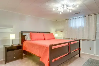 a bedroom with a bed with orange sheets and a window at 8 Mi to Dtwn Denver Wheat Ridge Gem with Patio in Wheat Ridge