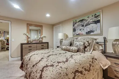 a bedroom with a bed and a dresser and a mirror at 1 Mi to Cherry Creek State Park Home with Game Room in Centennial