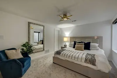 a bedroom with a large bed and a mirror at Luxury Townhouse in the Heart of LoHi in Denver