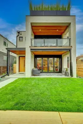 a house with a green lawn in front of it at Luxury Townhouse in the Heart of LoHi in Denver