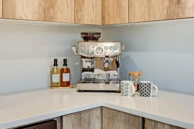 a kitchen counter with a coffee maker and bottles of wine at Luxury Townhouse in the Heart of LoHi in Denver