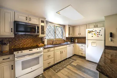 a kitchen with white appliances and a white refrigerator at Riverfront Condo Near Downtown Estes Park! in Estes Park