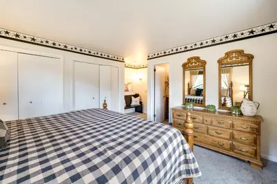 a bedroom with a bed and a dresser and a mirror at Riverfront Condo Near Downtown Estes Park! in Estes Park