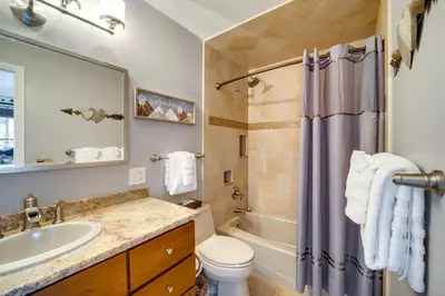 a bathroom with a sink and a toilet and a tub at Riverfront Condo Near Downtown Estes Park! in Estes Park