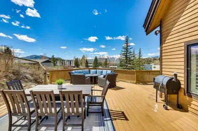 a patio with a table and chairs on a deck at 8 Mi to Keystone Home with Hot Tub in Dillon in Dillon
