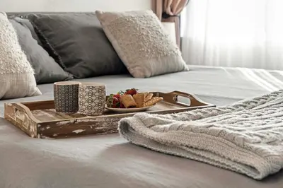 a tray with a plate of food on a bed at 1 Mi to Dtwn Cozy Retreat in Golden, CO! in Golden